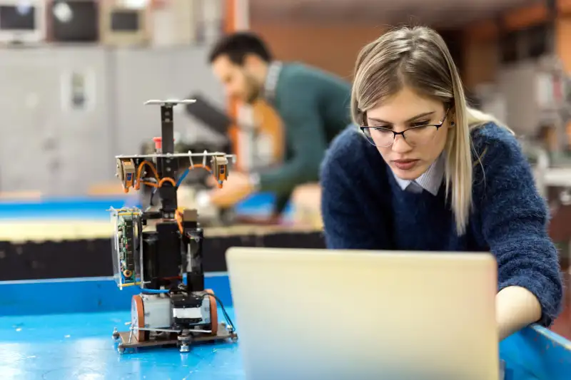 Woman engineer working on her computer in a robotics laboratory