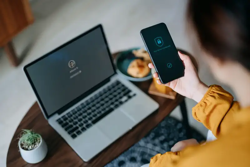 Woman unlocking phone and laptop