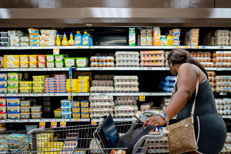Woman at a grocery store shopping for eggs