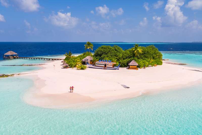 Aerial drone view of adult couple on a sandy beach, Maldives