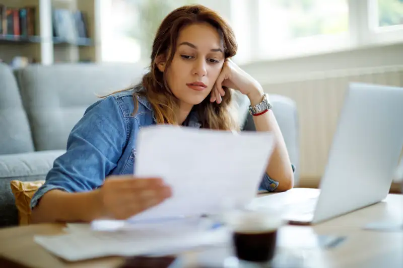 Woman looking over documents in her living room