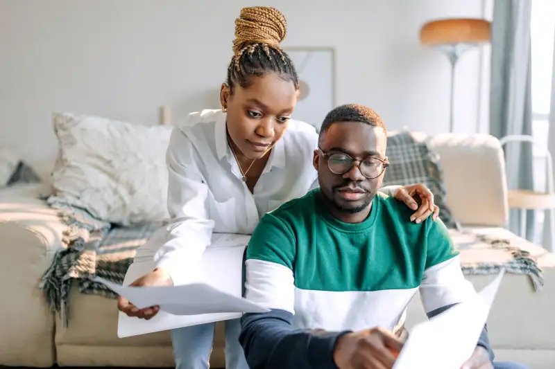 Couple looking over bills in their living room