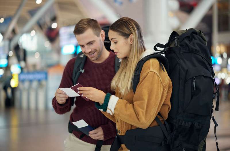 Couple looking at their passport and boarding pass at the airport
