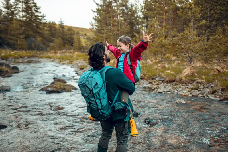 Father carrying his daughter in a forrest