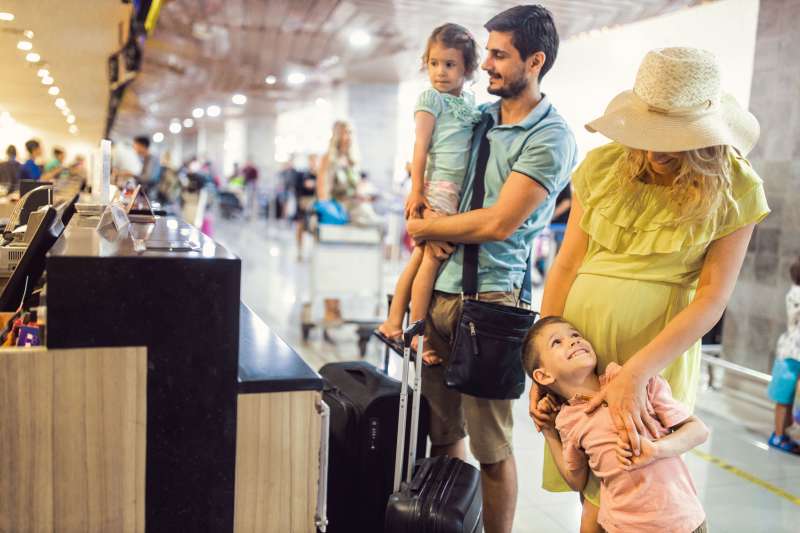 Family of four checking their luggage at the airport
