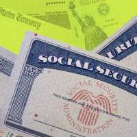 Photo collage of multiple social security cards stacked on top of each other and stimulus checks in the background