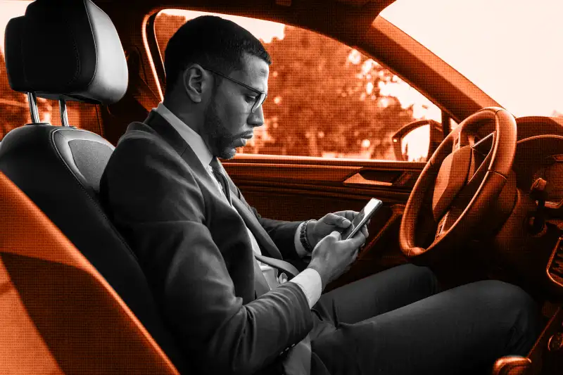 Man in his car looking at his phone