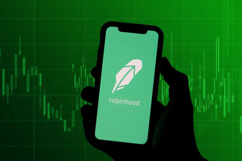 Robinhood app on phone with stock graph in the background
