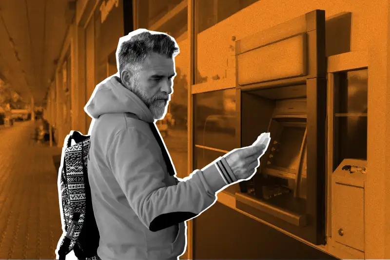 Man looking at his bank paper in front of an ATM