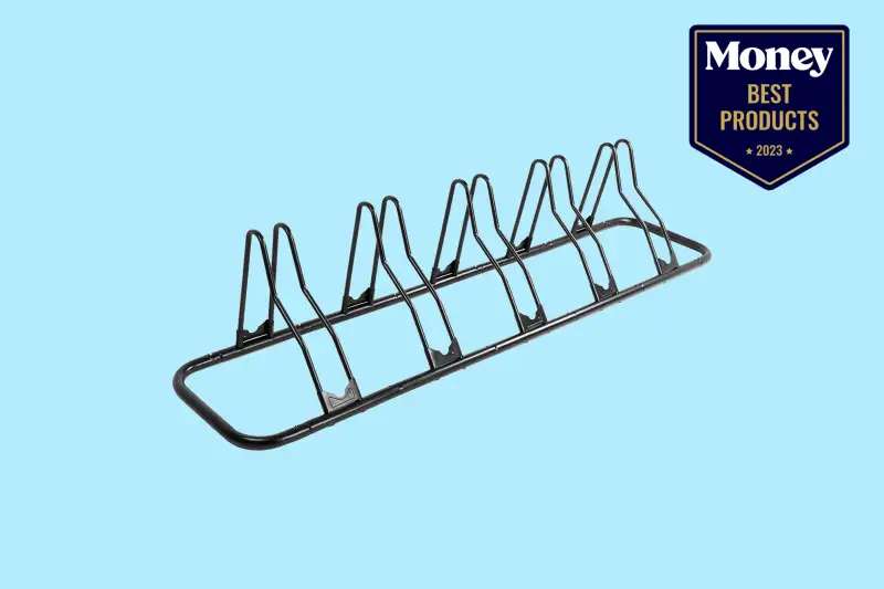 a black bike rack on a solid pale blue background