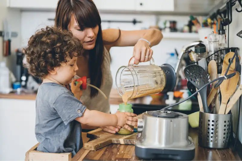 Mother and her little son preparing healthy smoothie