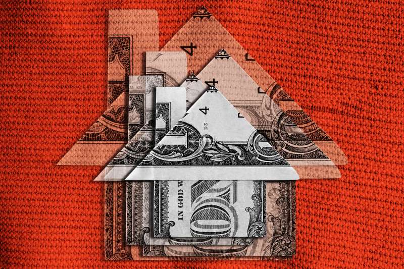 Photo Collage of multiple dollar bills folded up to look like a small house, stacked on top of each other in decreasing sizes