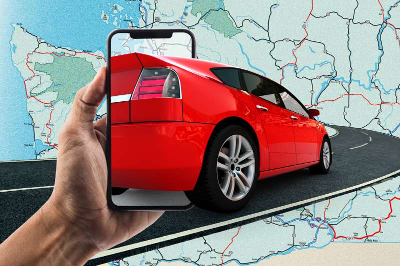 Photo Collage of a hand holding a smartphone where a red car is driving out of into a road, with a U.S. Map in the background