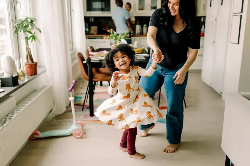 Mother and daughter dancing at home