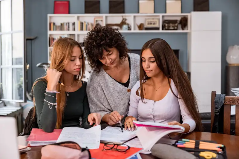 Mother helping her daughter to study on a research and homework