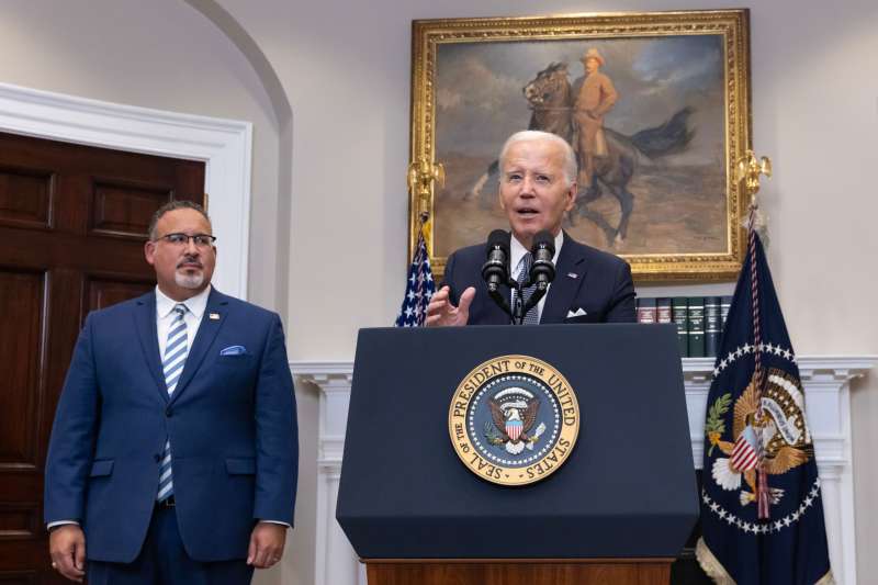 US President Joe Biden delivers remarks, beside US Secretary of Education Miguel Cardona