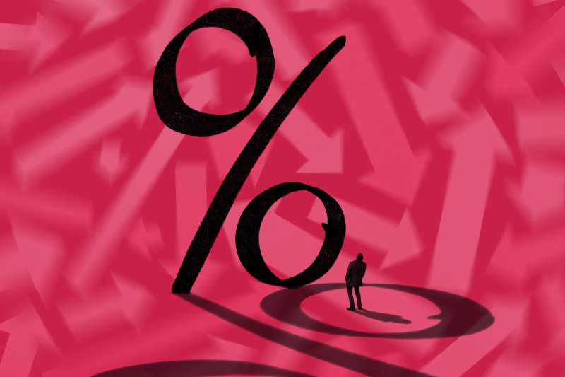 Photo illustration of a large percent sign casting a shadow with a man looking up at it.