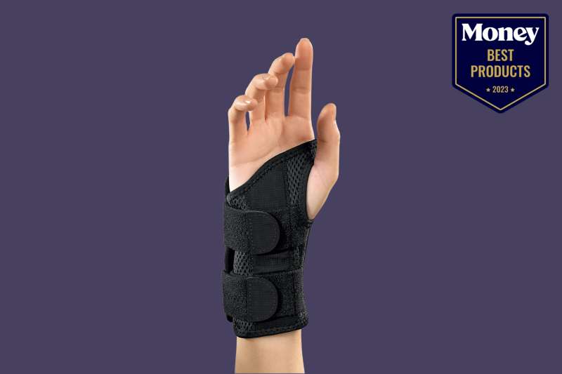 One of the best Wrist Braces for Carpal Tunnel on a fair-skinned person's hand, pictured on a deep purple backdrop