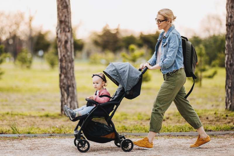 Nanny walks toddler in stroller