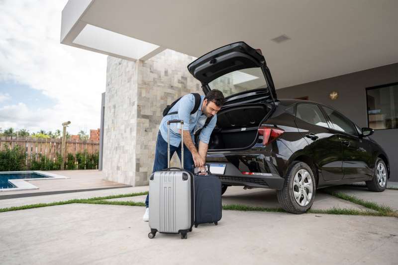 Man loading luggage into rental car