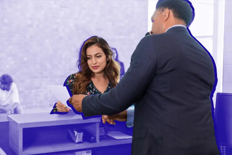 Bank teller helping woman at the bank.