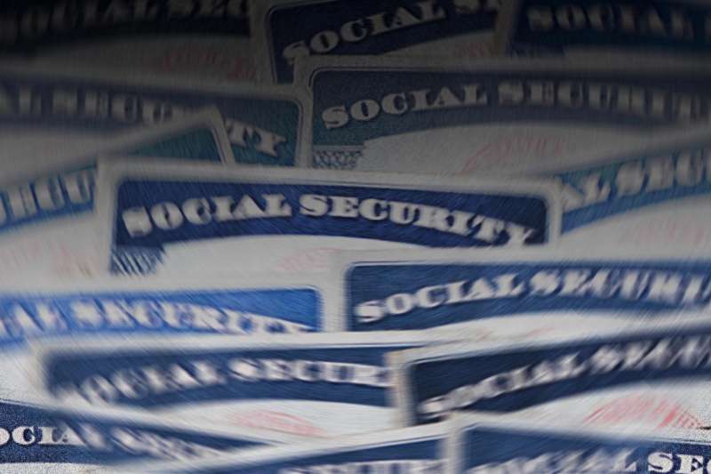 Photo-illustration of layered blurred social security cards.