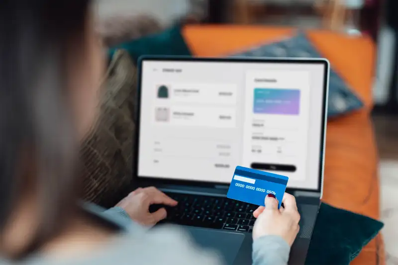 Person online shopping with credit card.