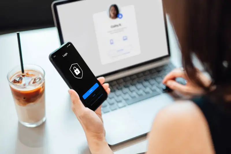 Woman using identity theft protection on her cell phone and laptop