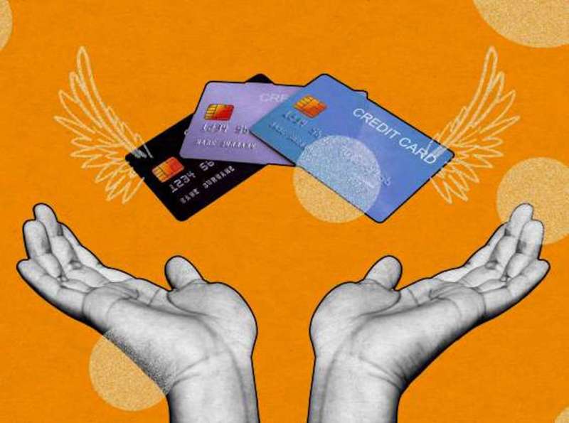 Graphic image with orange background and two hands forming angel wings with three credit cards above.