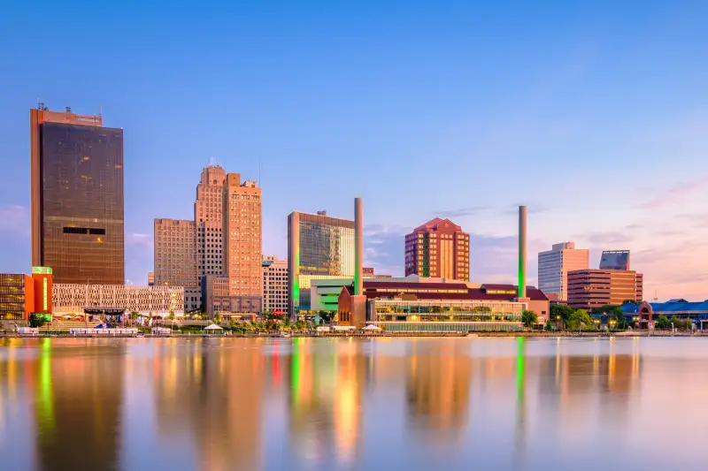 Toledo, Ohio, USA downtown skyline on the Maumee River at dusk.