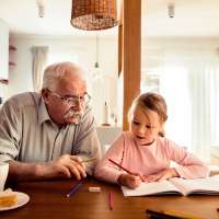 Grandfather helping his grand daughter do her homework at home