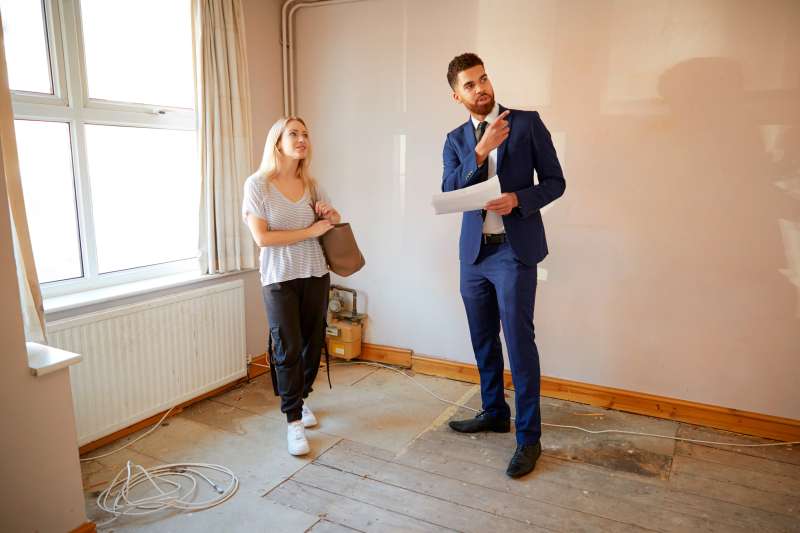 A real estate agent showing an apartment to a young woman