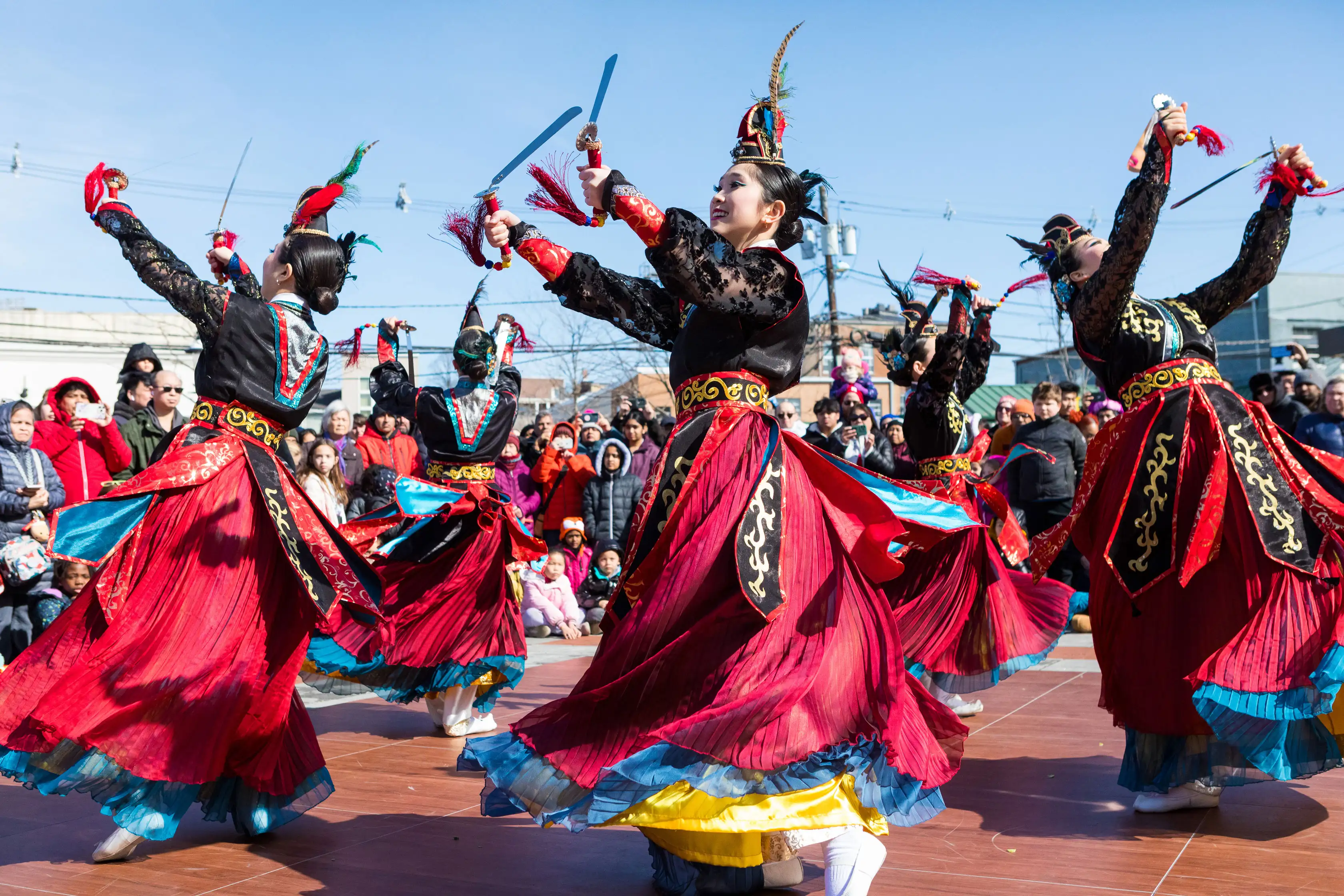 Women dressed in asian gowns performing a dance during street fair