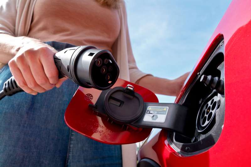 Close-up of a woman charging her electric vehicle