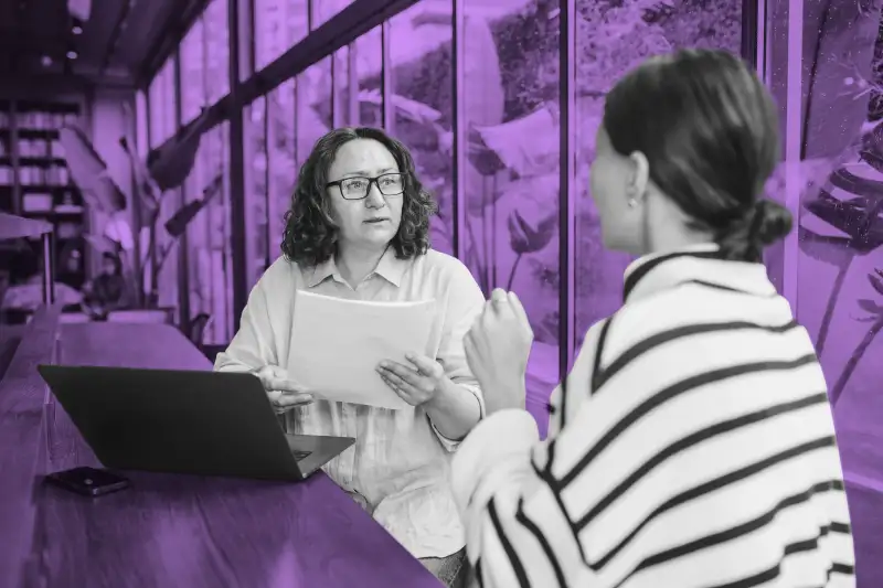 Two women discussing financial planning in an office space