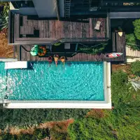 Aerial view of a three friends relaxing by the pool at a home